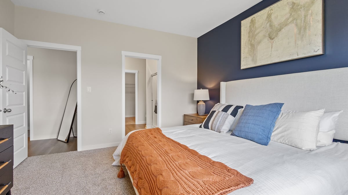 Primary bedroom with carpeted floors and own bathroom.