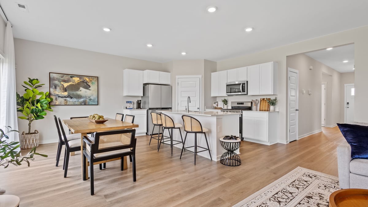 Kitchen and dining room with hard wood floors and white cabinets.