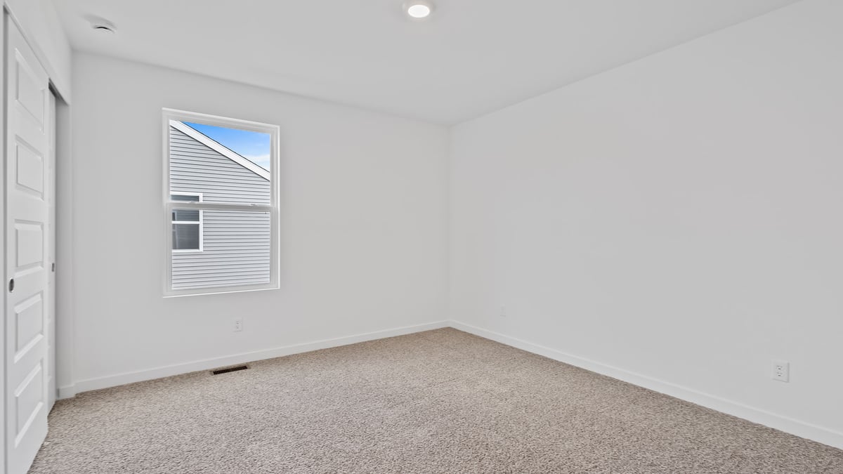 Bedroom with carpet and a window.