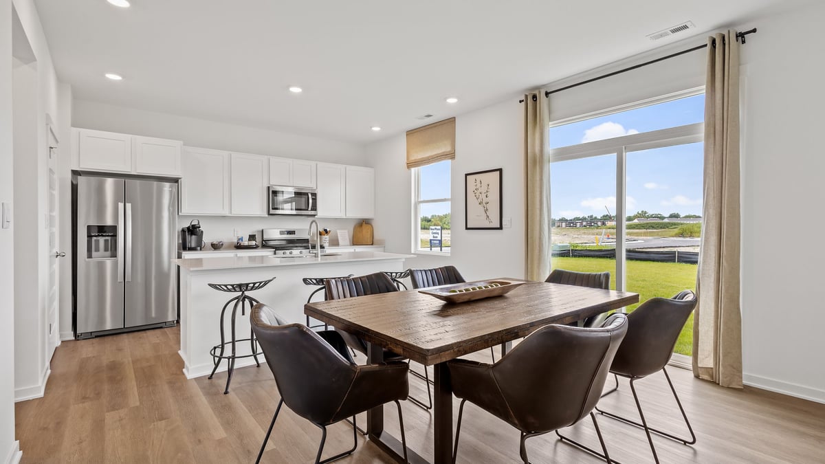 Dining area with glass sliding doors and view of kitchen.
