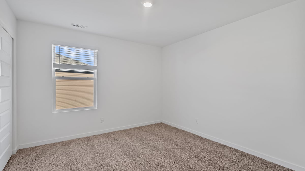 Bedroom with carpeted floors with a side window.