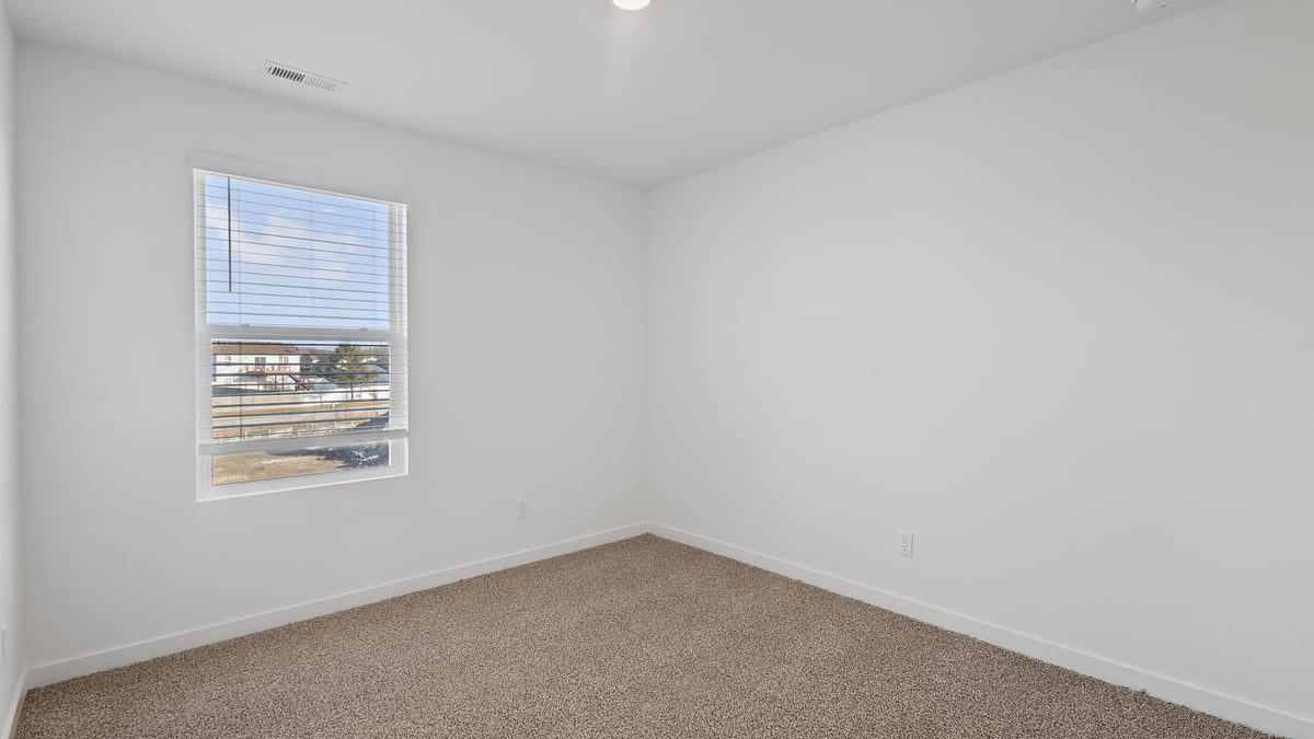 Bedroom with carpeted floors with a side window.