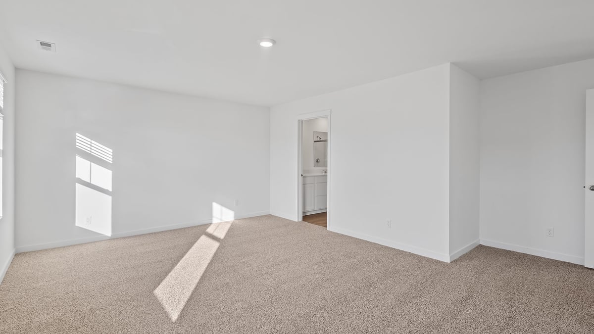 Primary bedroom with carpeted floors and great space.