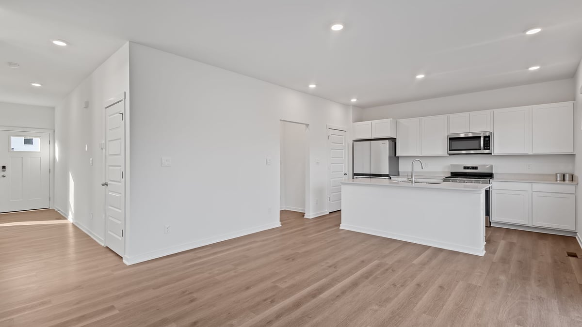 Dining and kitchen area with hard wood flooring.