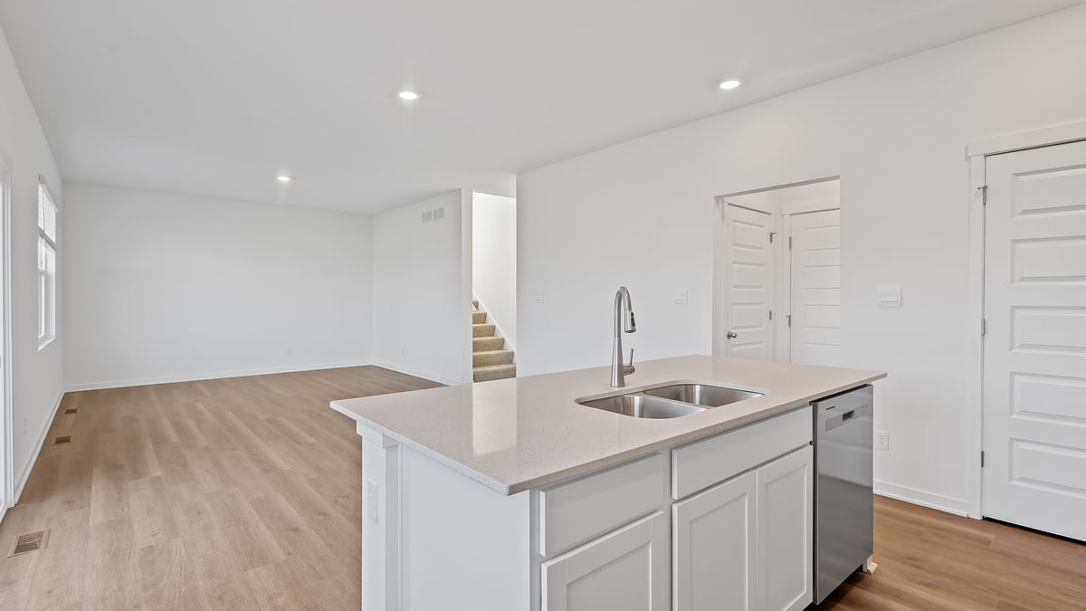 Kitchen island with quartz countertops and views of living room.