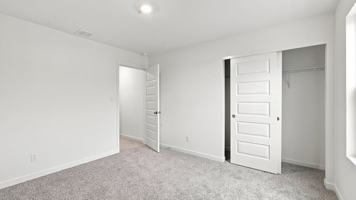 Bedroom with closet and carpeted floors.