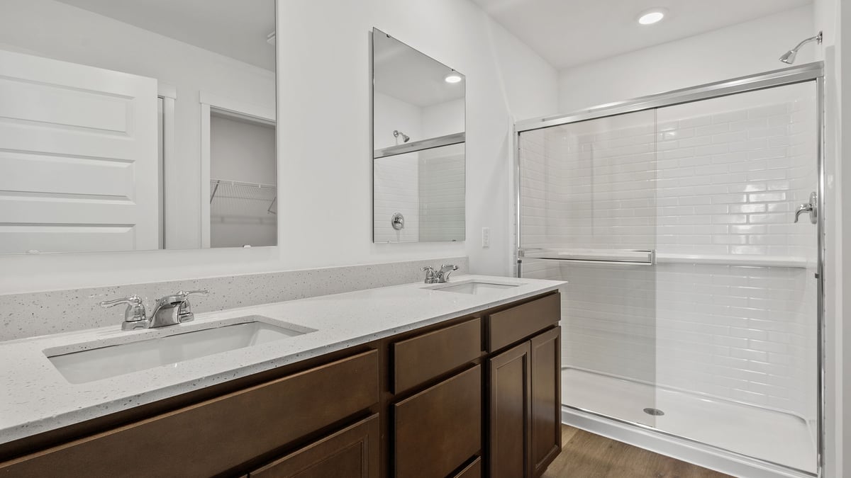 Primary bathroom with dual vanity sinks and a walk-in shower.