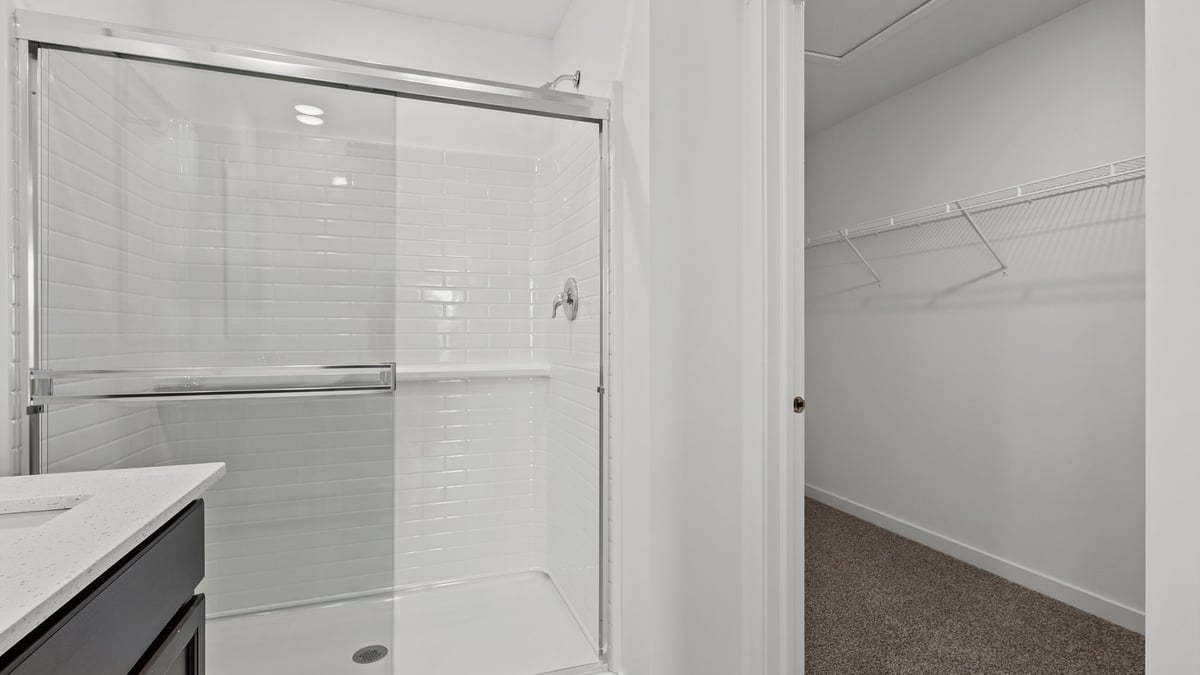 Primary bathroom with a walk-in shower and a walk-in closet.