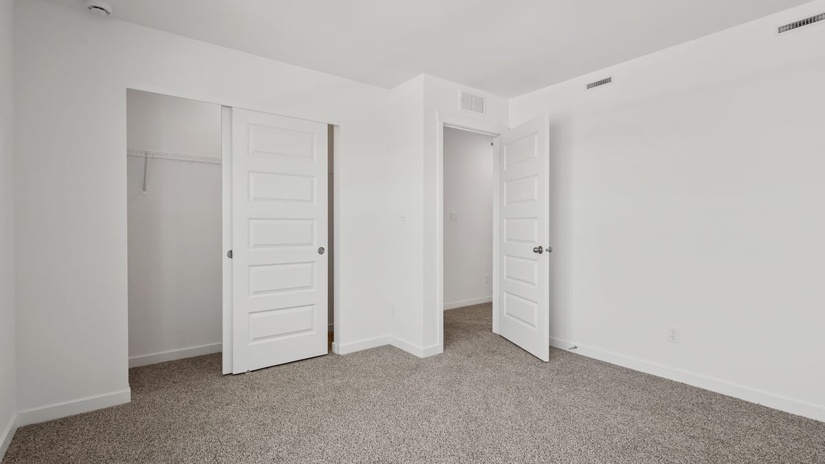 Bedroom with a closet and carpeted floors.