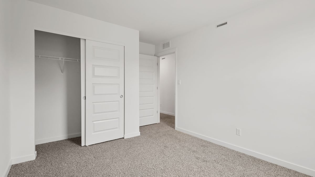 Bedroom with carpeted floors and a closet.