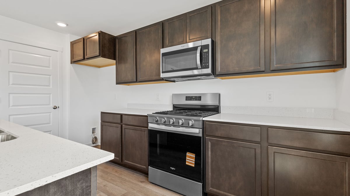 Kitchen with flagstone cabinetry and quartz counters.
