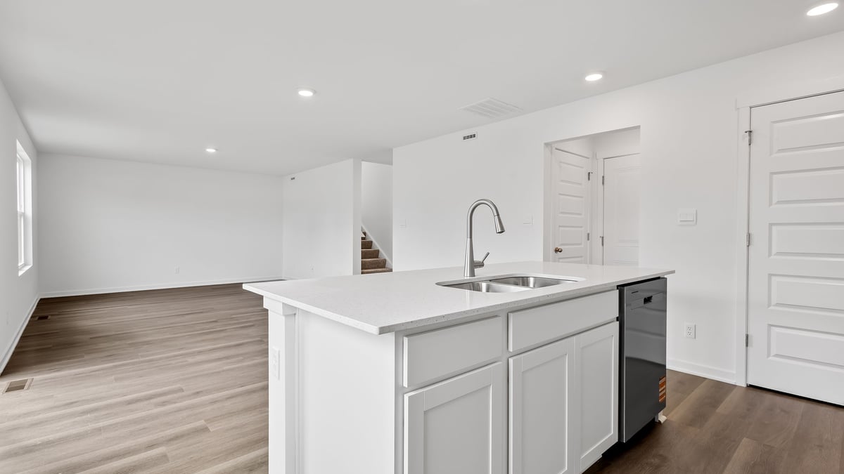 Kitchen island with hard wood floors and view of living area.
