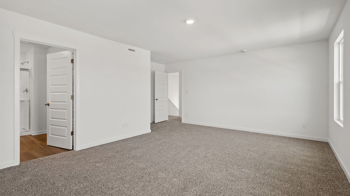 Bedroom with carpet and bathroom.