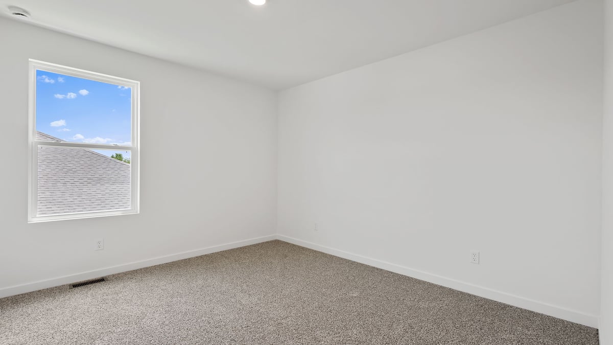 Bedroom with carpet and window.