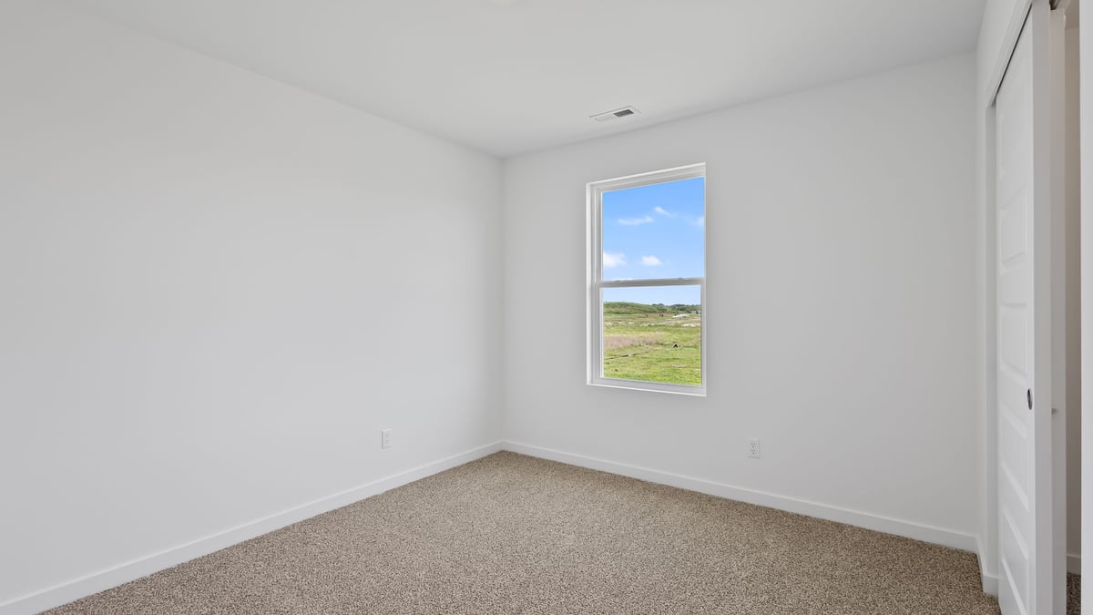 Bedroom with carpet and a window.