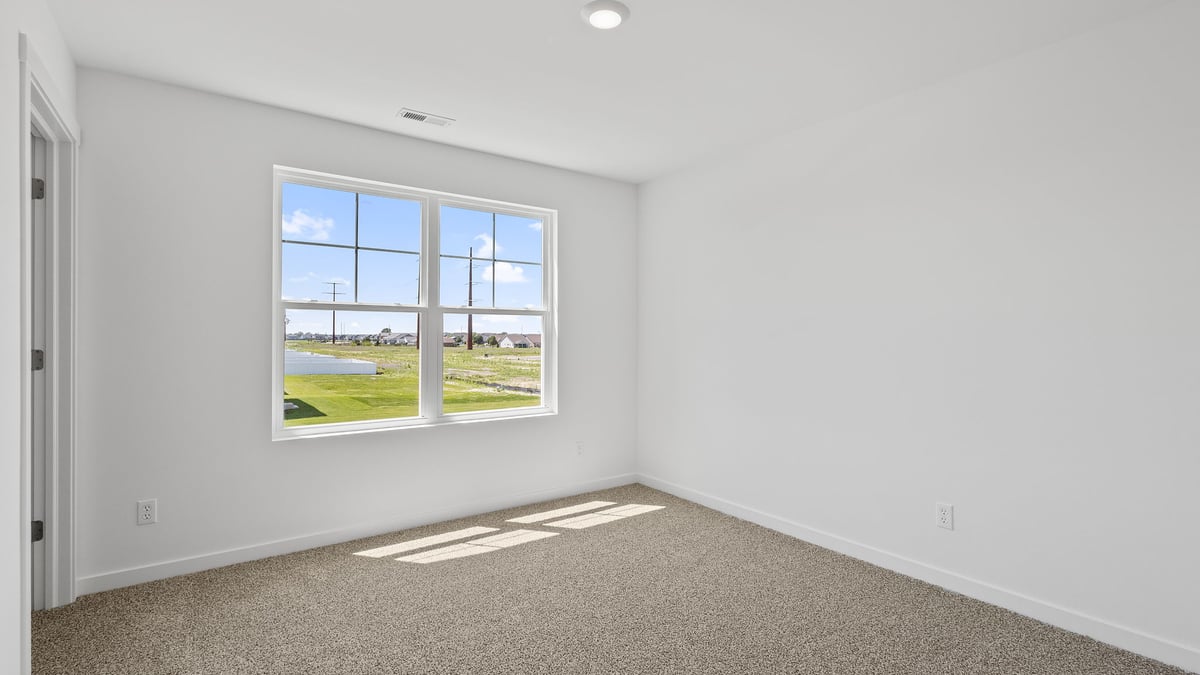 Bedroom with carpet and a big window.