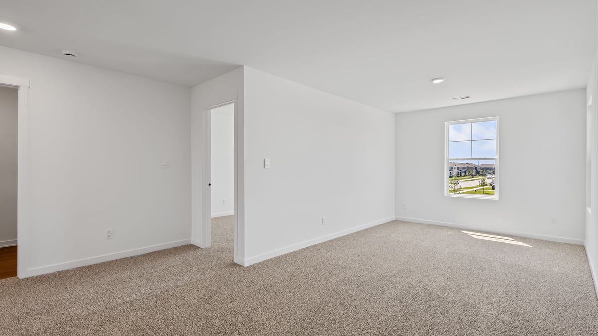 Loft room with carpet and window.