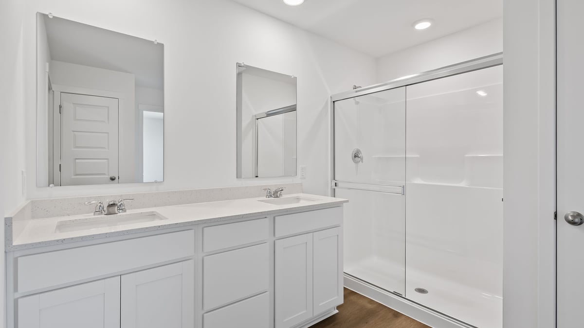 Dual vanity sinks with a walk in shower.