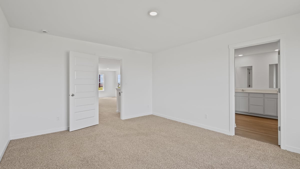 Bedroom with carpet and bathroom.
