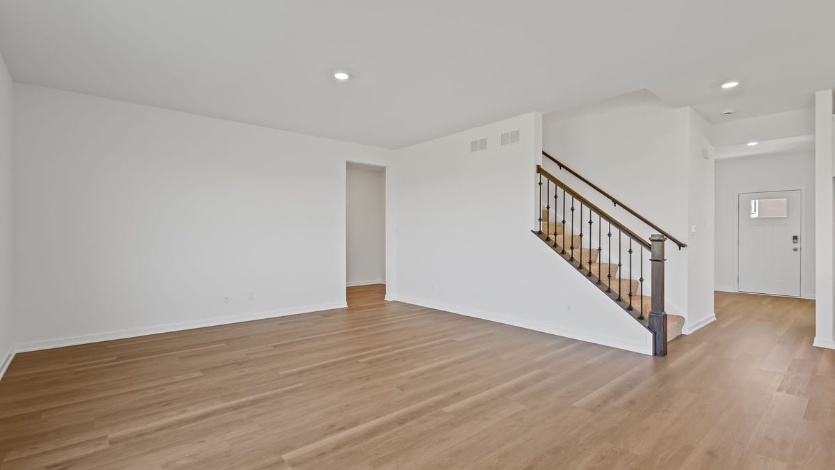 Living area with open concept and view of staircase.