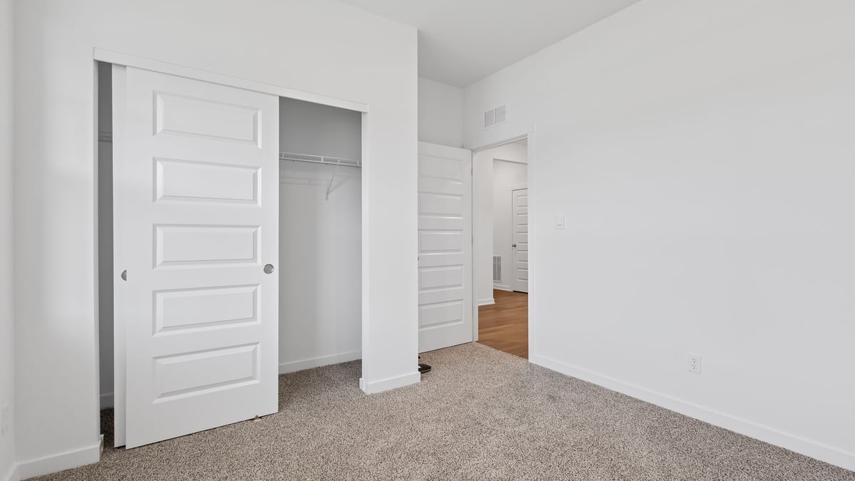 Bedroom with a closet and carpeted floors.