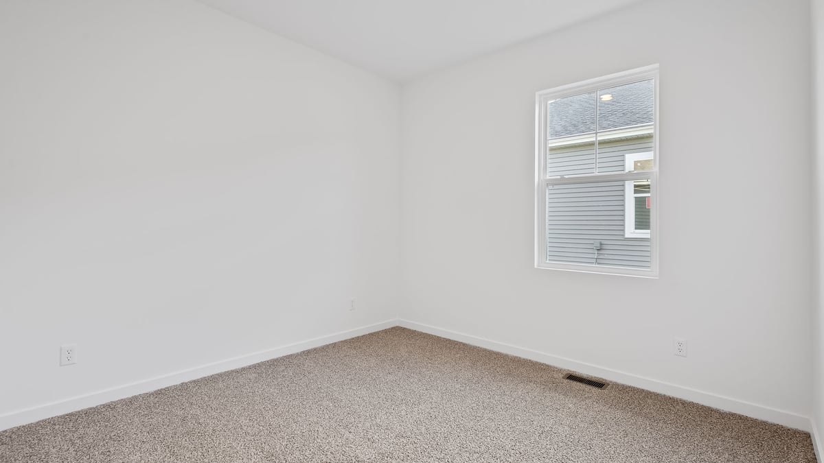 Bedroom with a side window and carpeted floors.