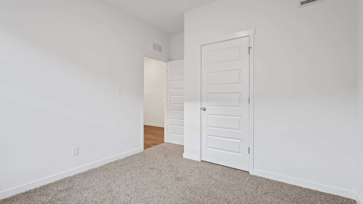 Bedroom with a closet and carpeted floors.