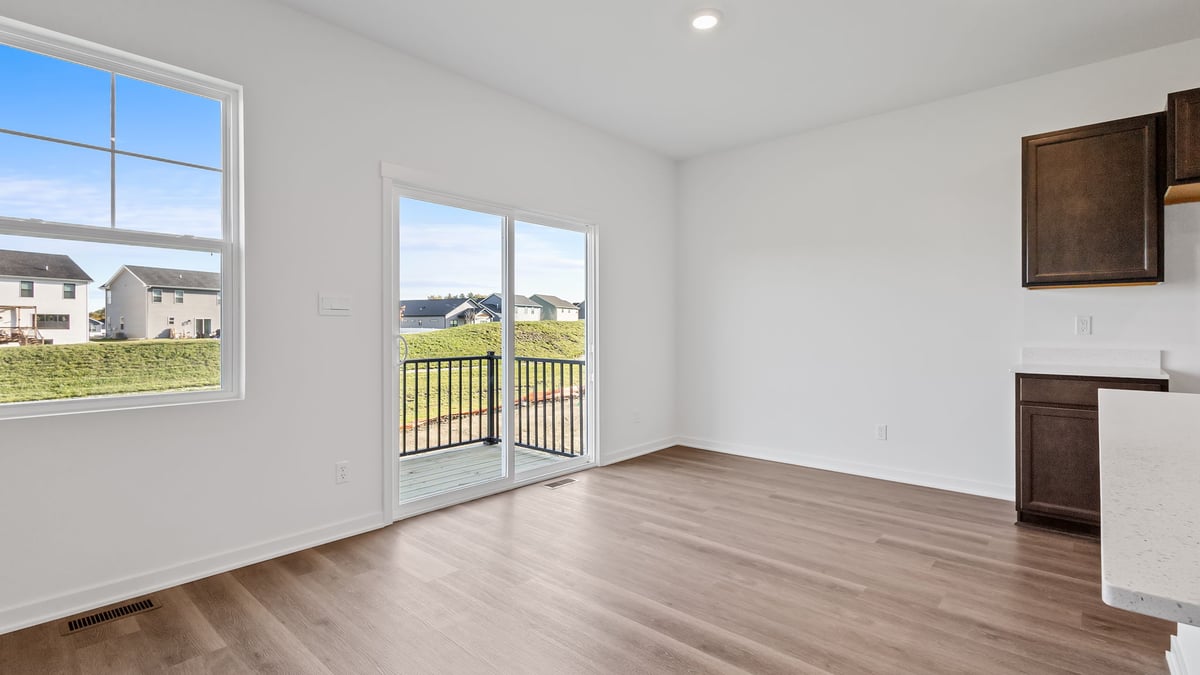 Dining area with a glass sliding door and hard wood flooring.