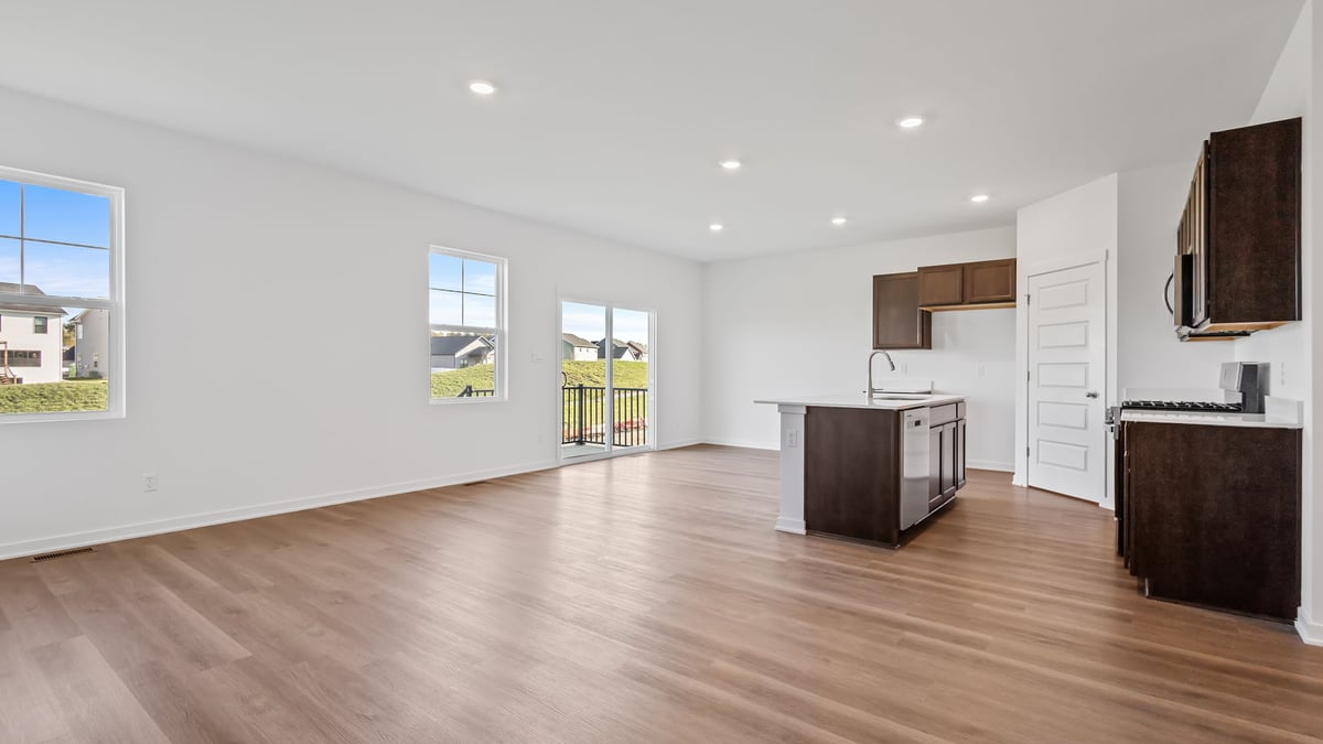 Living room area with hard wood flooring and windows and great space.
