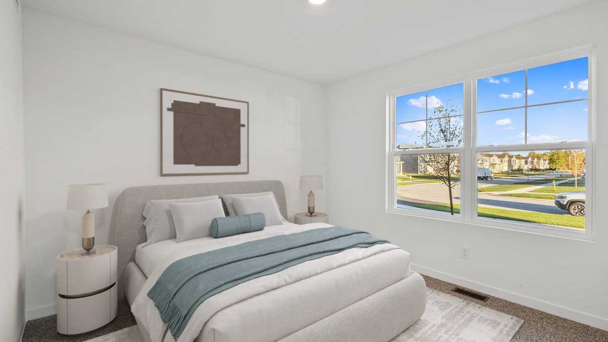 Bedroom with a big window and carpeted floors.