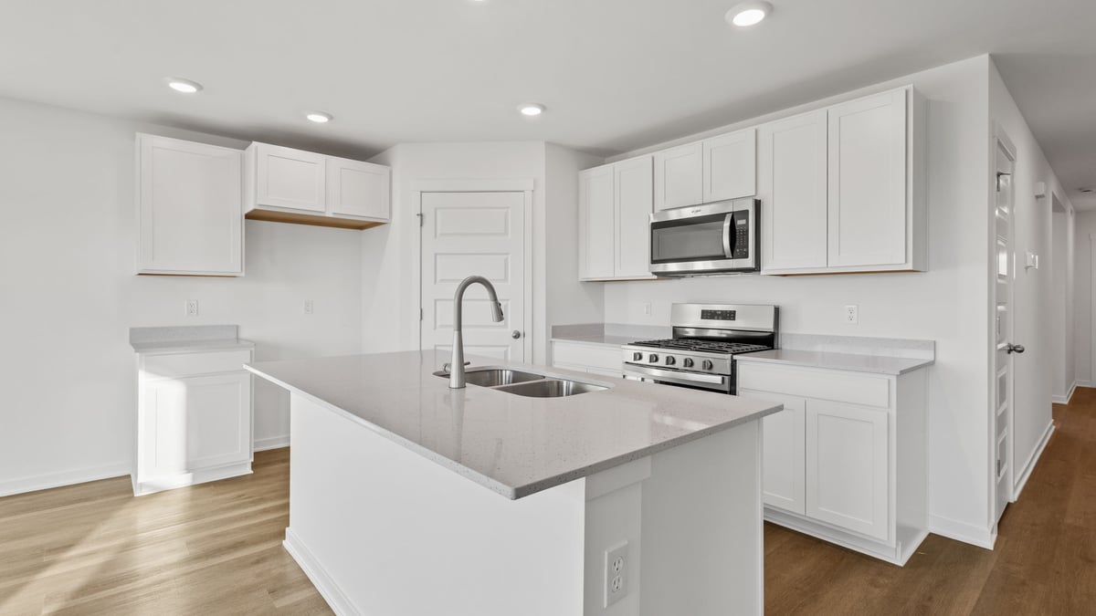 Kitchen with hard wood floors and a white cabinetry kitchen.