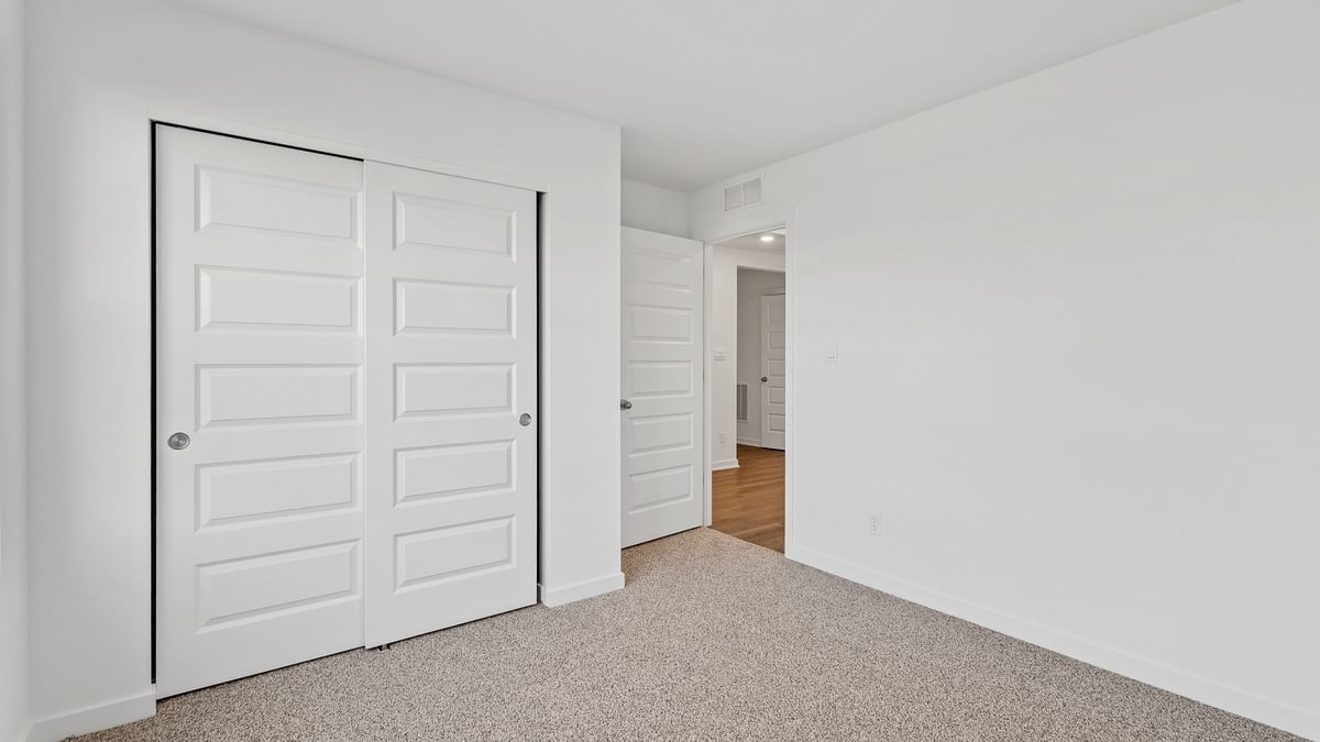 Bedroom with carpeted floors and a closet.