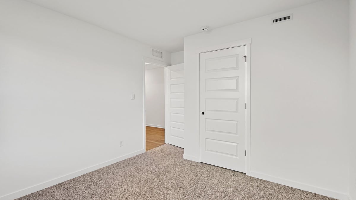 Bedroom with carpeted floors and a closet.