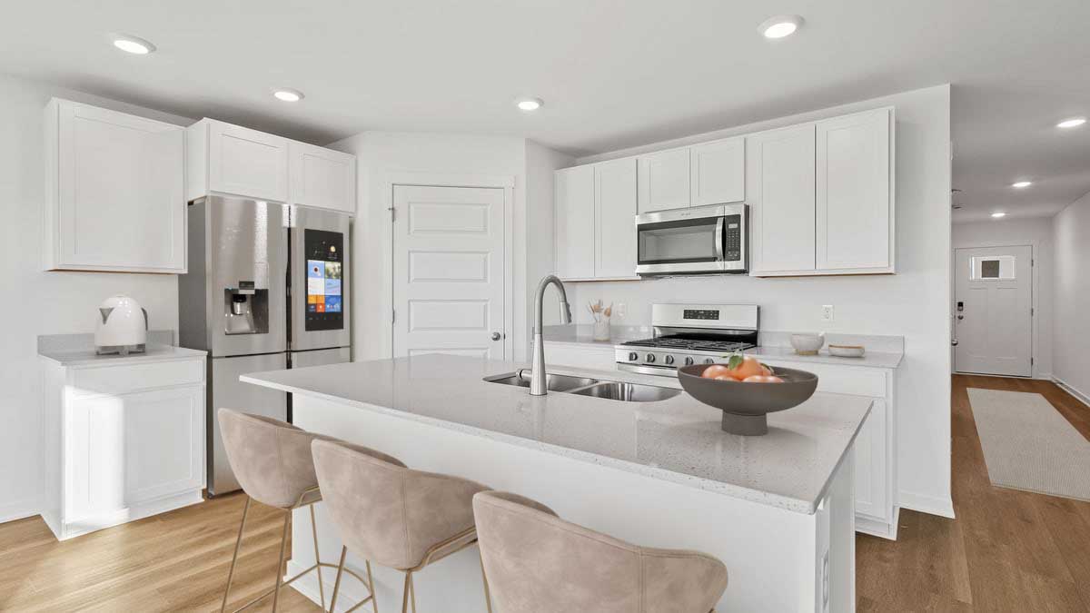 Kitchen with white cabinetry and hard wood floors.