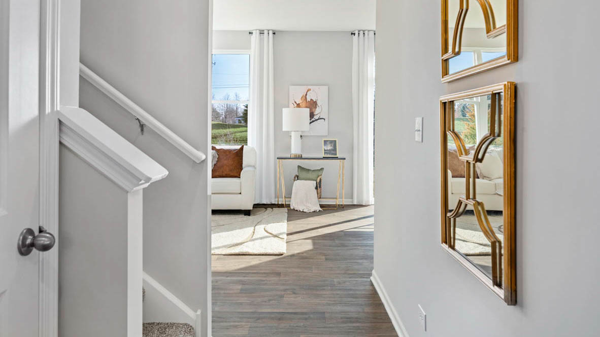 Entryway with a hall leading into a staircase and the living area.