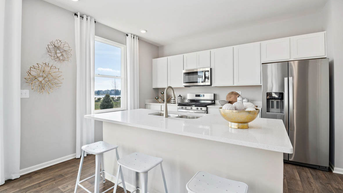 Kitchen featuring white cabinets, stainless steel appliances, and white countertops.