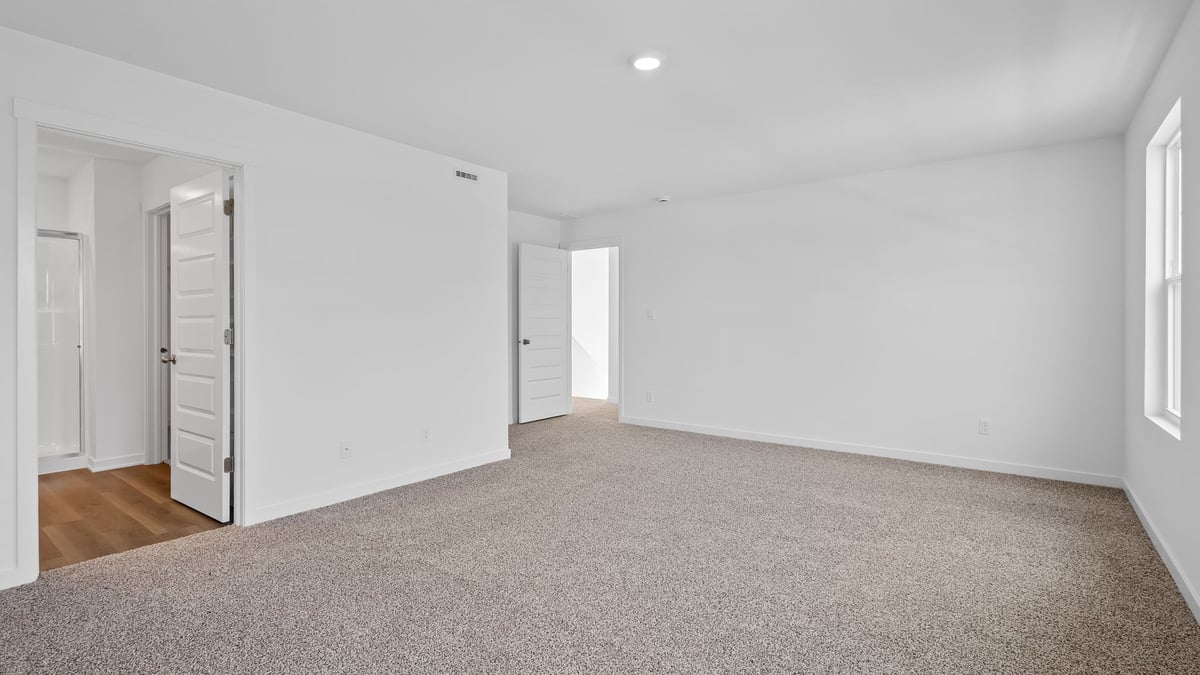 Bedroom with carpet and bathroom.