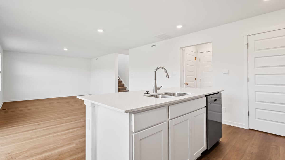 Kitchen island with quartz countertops and hard wood flooring.