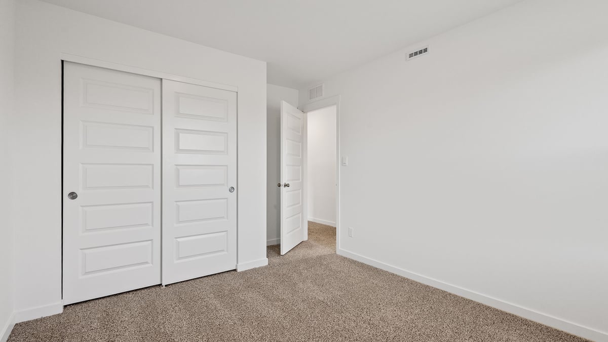 Bedroom with carpeted floors with a closet.