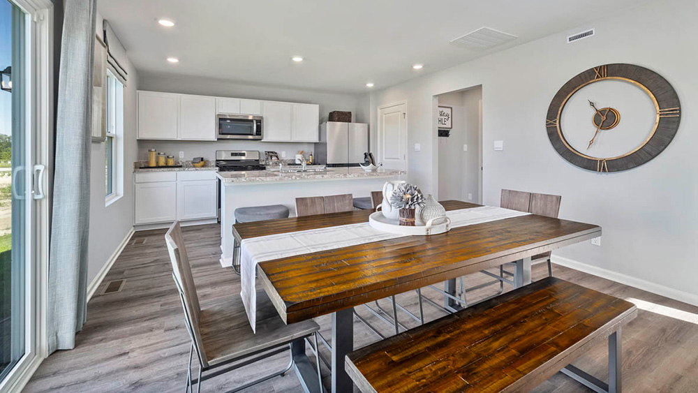 Dining area with a view of kitchen with hard wood flooring.