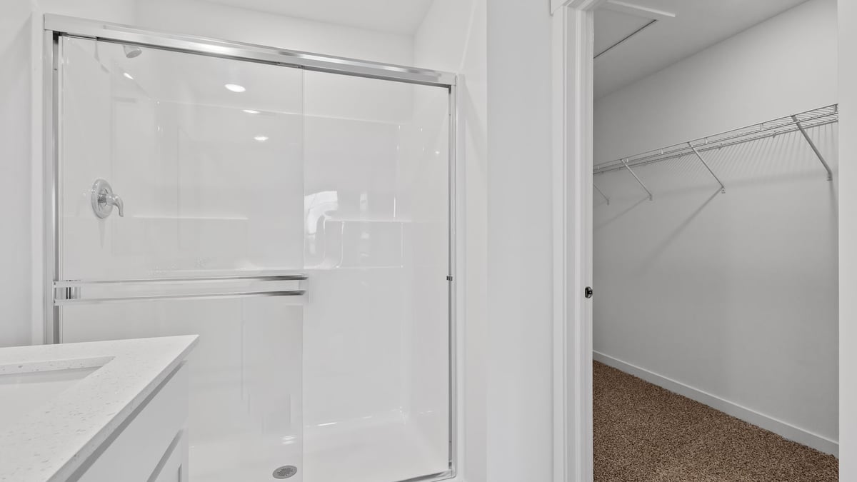 Bathroom with a walk in shower and a walk in closet.