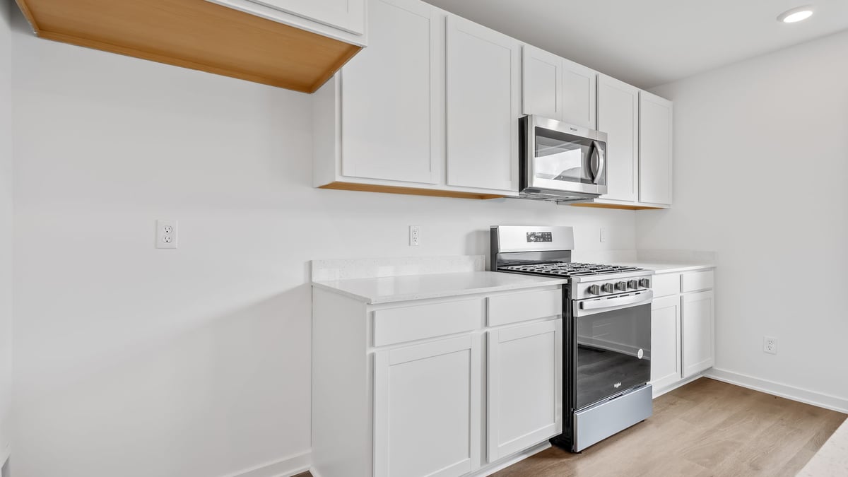 Kitchen with white cabinets and a microwave.