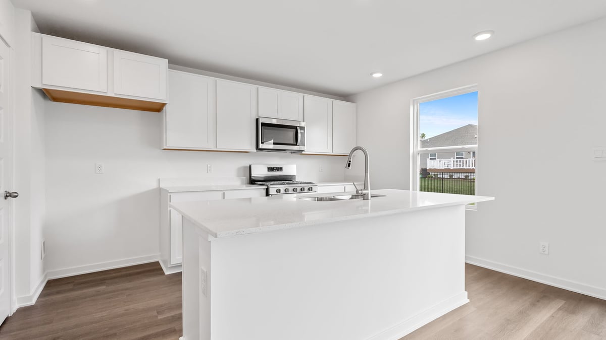 Kitchen with white cabinets and a kitchen island with a window.