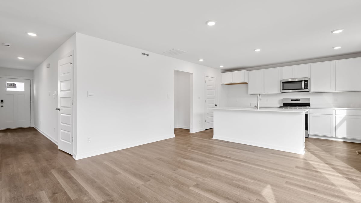 Living area with view of hallway to front door and the kitchen.