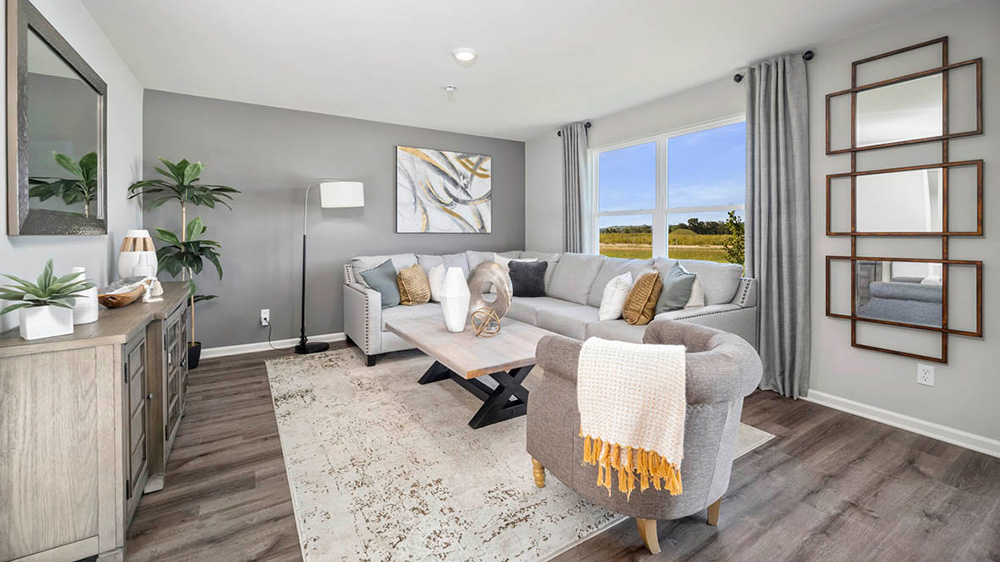 Living area with hard wood floors and a big window.