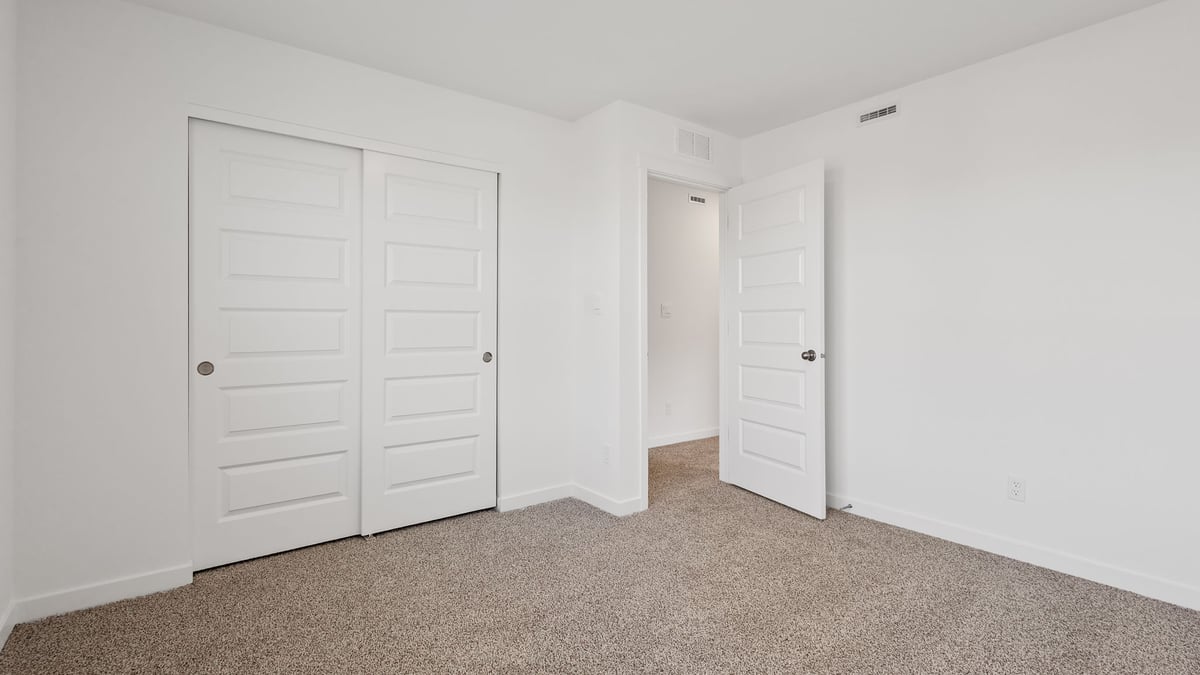 Bedroom with carpeted floors and a closet.