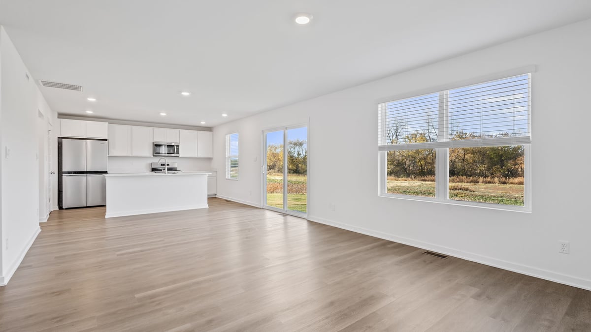 Living area with hard wood floors and a big side window.