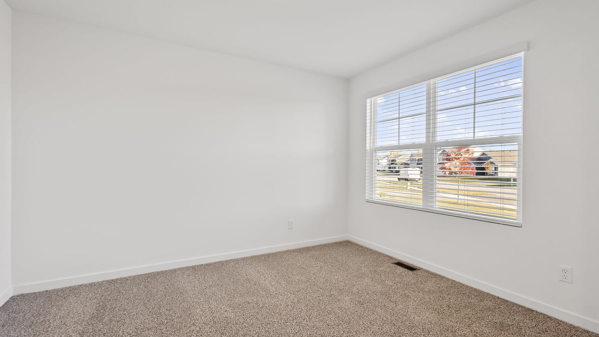 Front room with carpeted floors and a big window.