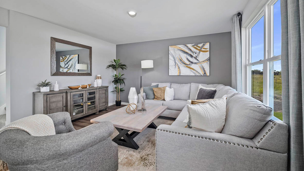 Living area with a big side window and hard wood floors.