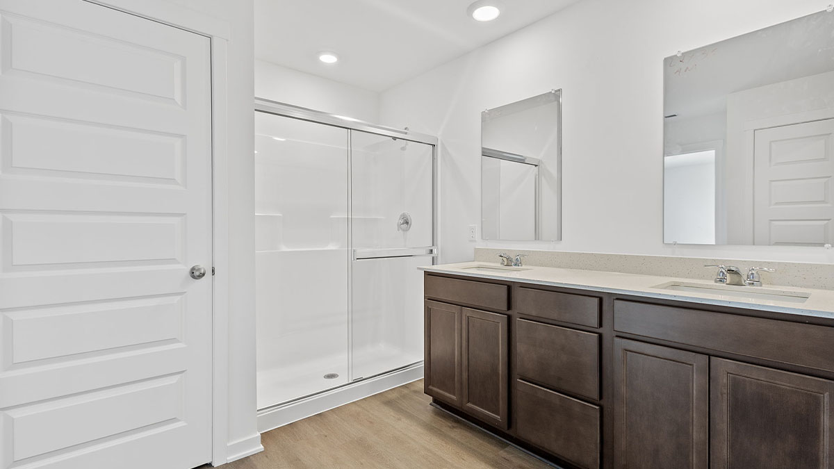 Bathroom with dual vanity sink and a walk in shower.